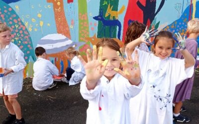 Les CE1 ajoutent leur touche à la fresque de l’école.